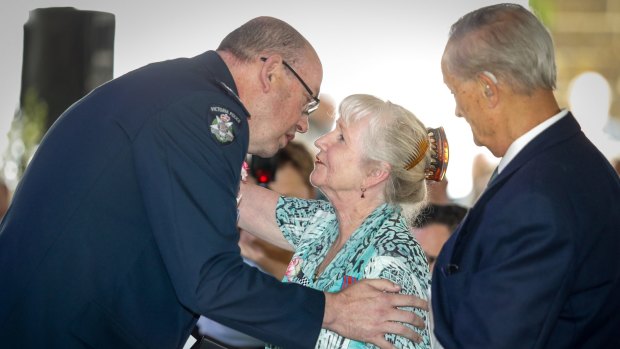 Chief Commissioner Graham Aston presents a National Police Service Medal to Angela Taylor's parents Marilyn and Arthur.  