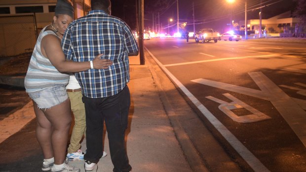 Bystanders wait down the street from a the nightclub shooting.