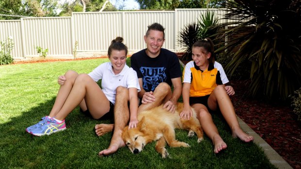 Andrew McInnes with daughters Courtney,15 (left), and Taya,13, and their dog Gypsy, at home in Queanbeyan. 