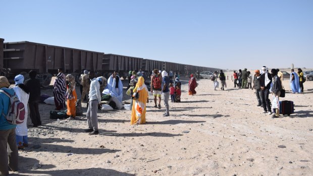 Passengers wait to board the train.