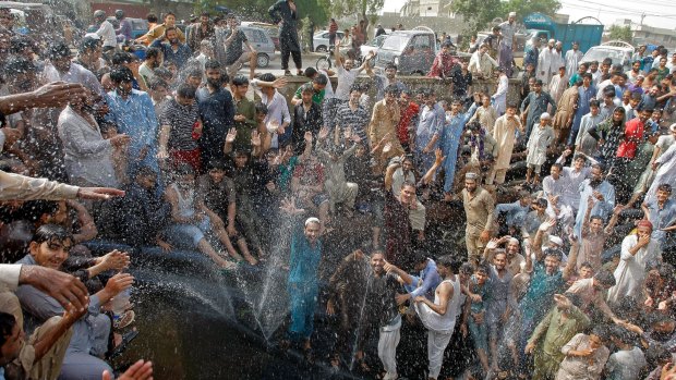 People cool off in a spray from a broken water pipe during a heat wave in Karachi, Pakistan last month.