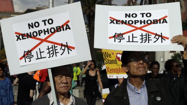 Asian nationals hold placards reading "no to xenophobia" during a march in Johannesburg.