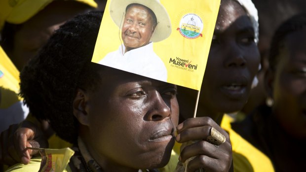 A supporter holds a flag of Uganda's long-time President Yoweri Museveni at an election rally in Kampala on Tuesday. 
