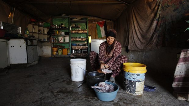 A Palestinian woman cooks in her family tent in the village of Susiya, south of the West Bank city of Hebron. 
