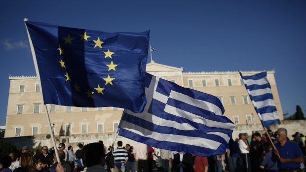 Waving a flag: The Tsipras government is offering new budget cuts to the "troika" that negotiated Greece's 2010 bailout and its 2012 extension.
