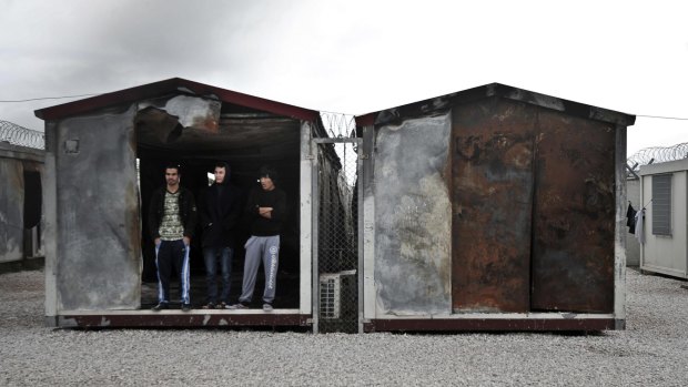 Immigrants at the entrance of a container in the detention centre.