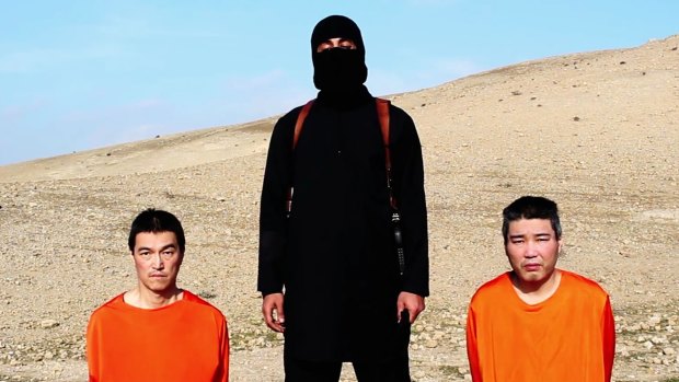 An IS militant with the two Japanese hostages, journalist Kenji Goto Jogo, left, and military contractor Haruna Yukawa.