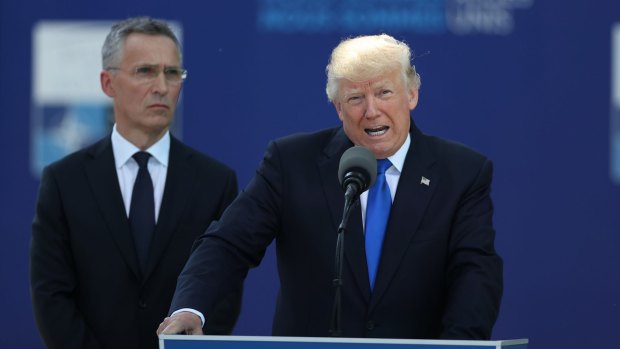 US President Donald Trump speaks as Jens Stoltenberg, secretary general of NATO, looks on.