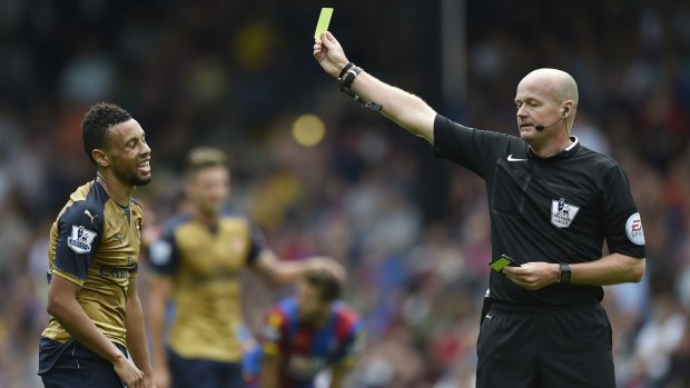 Arsenal's Francis Coquelin is shown a yellow card by referee Lee Mason at Selhurst Park.