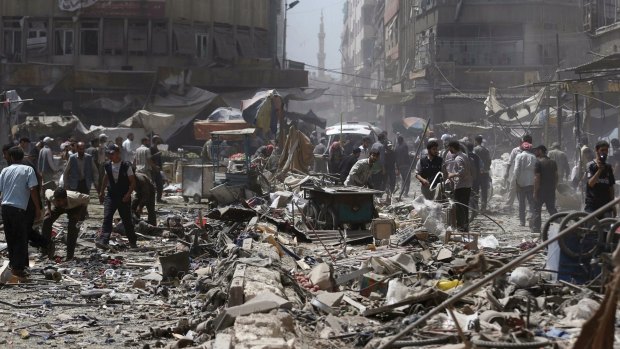 People inspect a site hit by what activists said were air strikes by forces loyal to Syria's President Bashar al-Assad on a marketplace in Douma on Sunday.