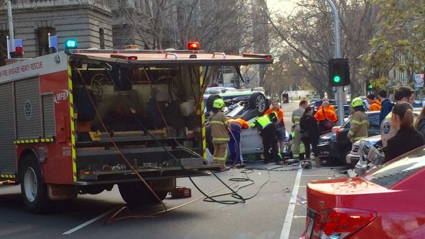 A man is rescued from a car wreck on Queens Street in Melbourne's CBD.