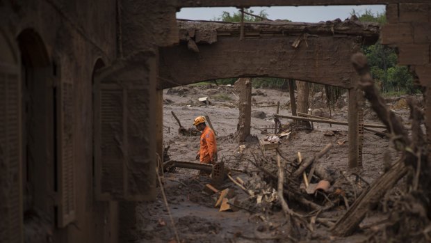 A rescue worker walks between destroyed houses in the town of Bento Rodrigues after the Fundao dam burst in Minas Gerais, Brazil.
