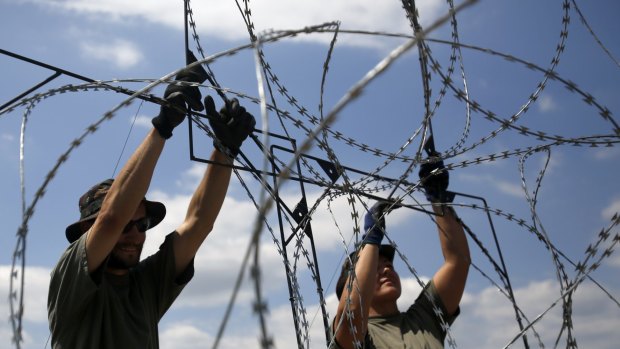 Hungarian soldiers place barbed wire near Morahalom, Hungary on Thursday.