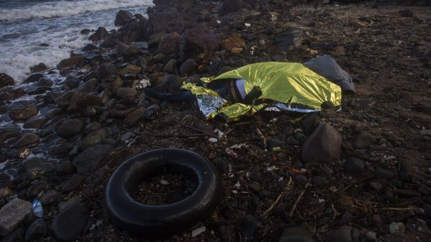 The body of an unidentified man is covered with a foil blanket after washing up on the shoreline at the village of Skala, on the Greek island of Lesbos, on Sunday.