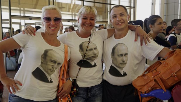 Russian tourists wear T-shirts with images of Russian President Vladimir Putin pose in the departure terminal before  boarding a flight from Sharm el-Sheikh, Egypt, on Friday.