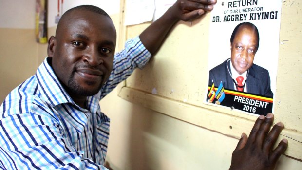 A student puts up campaign material for Ugandan opposition presidential candidate Aggrey Kiyingi in Kampala. 