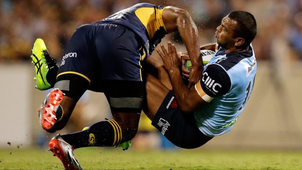 Down you go: Kurtley Beale of the Waratahs is upended by Tevita Kuridrani of the Brumbies.