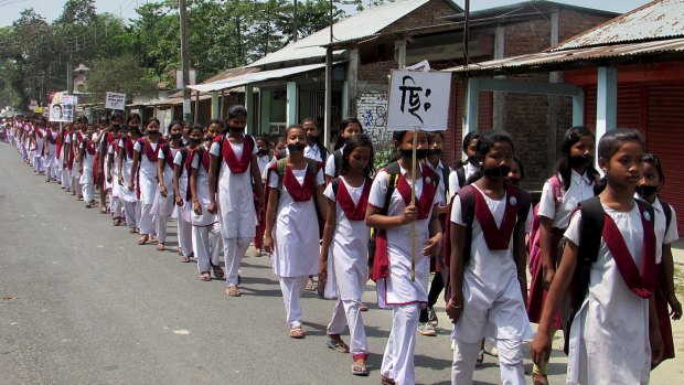Schoolgirls wear black gags during a protest over the rape of a 16-year-old girl at Dhupguri town in the Indian state of West Bengal.