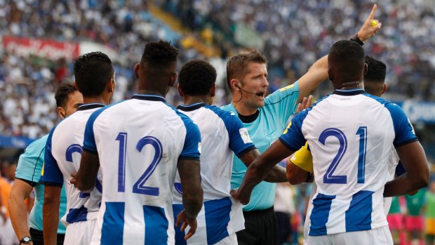 Italian referee Daniele Orsato warns off Honduras players during the first half.