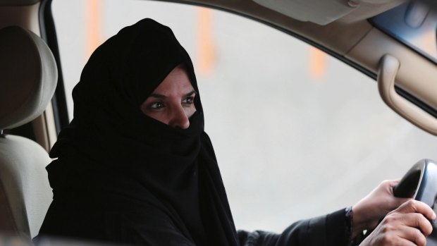 A woman drives a car on a highway in Riyadh.