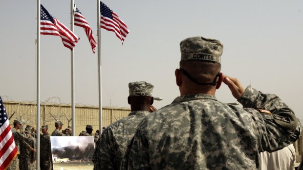 US Army soldiers saluting  American flags  at a ceremony at Camp Liberty in Baghdad  in 2008. 