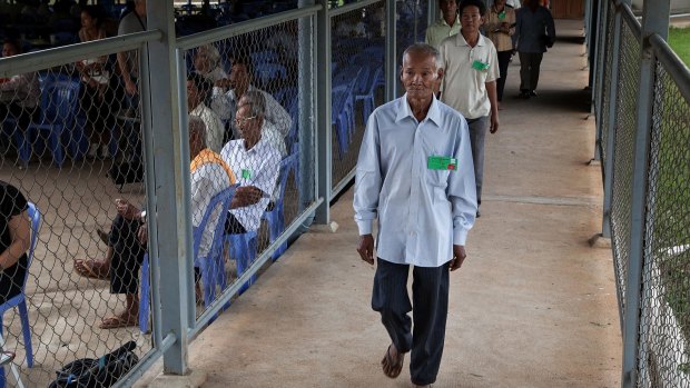 A group of survivors of the Khmer Rouge regime walk to the courtroom for the verdict in the trials of Nuon Chea and Khieu Samphan in August 2014.