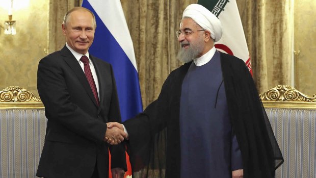 Irania President Hassan Rouhani, right, welcomes Russian President Vladimir Putin to the Saadabad Palace in Tehran on Wednesday.