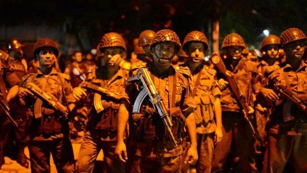 Bangladeshi security stand guard near a restaurant that has been attacked by gunmen.