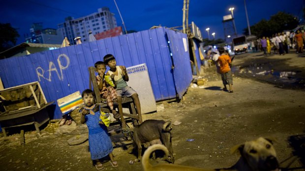 Children of street venders eat a roadside meal as street dogs walk around Yangon, Myanmar, on Wednesday. On Sunday Myanmar will hold what is being viewed as the country's best chance for a free and credible election in a quarter of a century. 