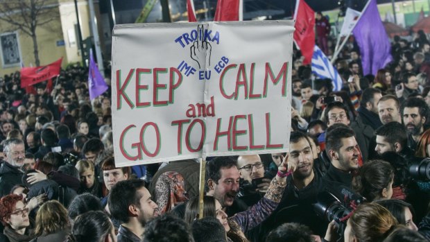 Syriza supporters make their feelings about the "Troika" managing Greece's bailout clear.