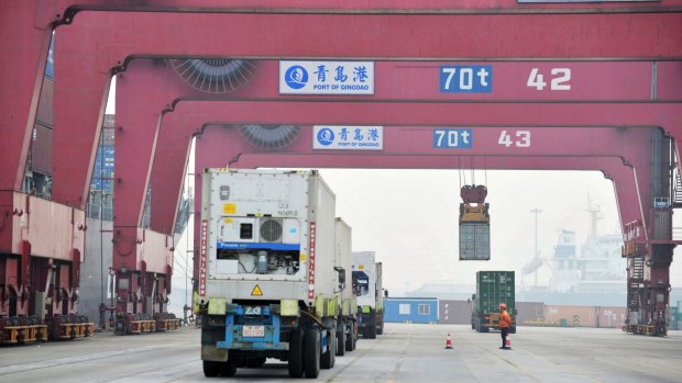 Cargo trucks move through a shipping port in Qingdao in eastern China's Shandong province. 