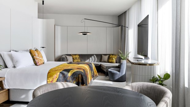 Bedroom interiors balance the weight of the brutalist architecture with undulating forms, bold hues and plush materials like a mustard suede lounge.