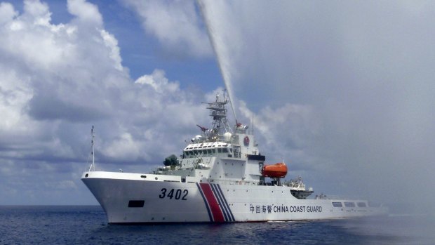 A Chinese Coast Guard boat sprays a water cannon at Filipino fishermen near Scarborough Shoal in the South China Sea last year.