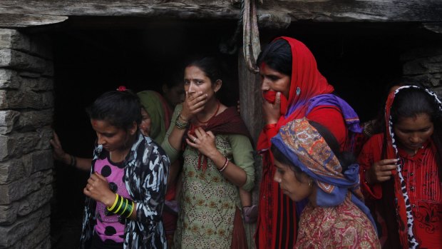 Nepalese women react after rescuers recovered a dead body of a victim from the debris after a landslide in Lumle village.