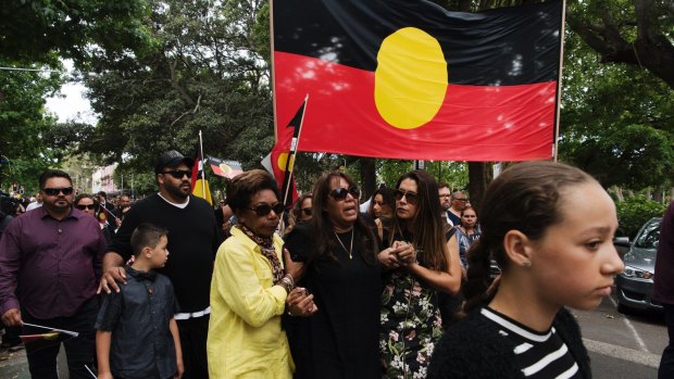 The daughter of the late Sol Bellear, Tamara Bollear-Mayers, is consoled while marching to the state funeral of the Aboriginal activist.