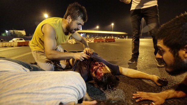 A wounded man lies on the ground after clashes with Turkish military at the entrance to the Bosphorus Bridge in Istanbul.