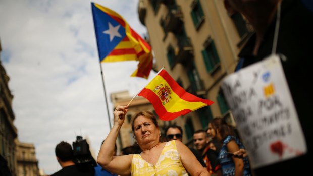 A woman holds a Spanish flag in support of  police as pro-independence protesters gather in front of the national police headquarters in Barcelona on October 3.