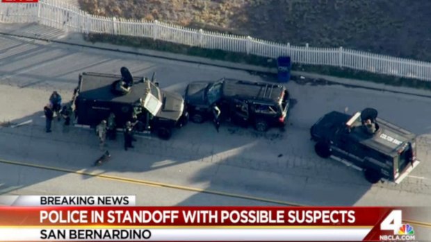 Armored vehicles surround an SUV following a shootout in San Bernardino.