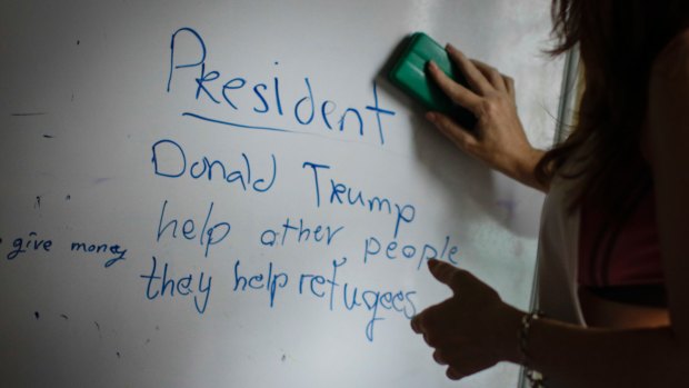 A volunteer teacher erases the board after her English lesson to Christian Burmese refugees in Kuala Lumpur, Malaysia. 