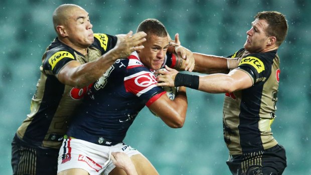 Tough going: Kane Evans puts a fend on Trent Merrin.