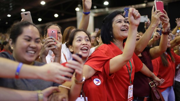 Filipino supporters cheer as Philippine President Rodrigo Duterte arrives to meet the Filipino community in Singapore on Friday.