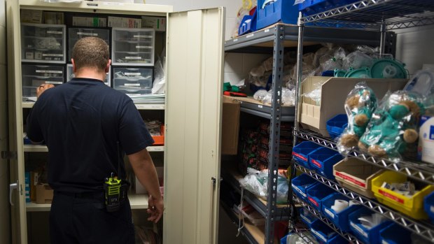 Doug Rolf, a firefighter and medic restocks medicine after responding to an overdose, in Colerain, Ohio.