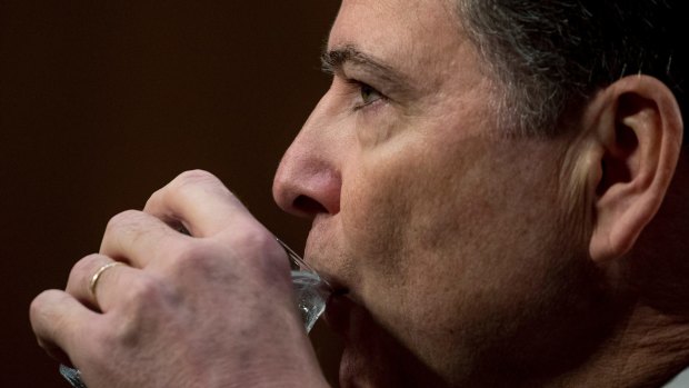 Former FBI director James Comey takes a drink of water as he testifies at a Senate Intelligence Committee hearing on Thursday.