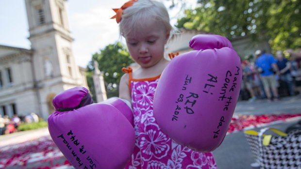 Lena Worthington, 2, of Louisville, waits for the arrival of Muhammad Ali's funeral procession on Friday.
