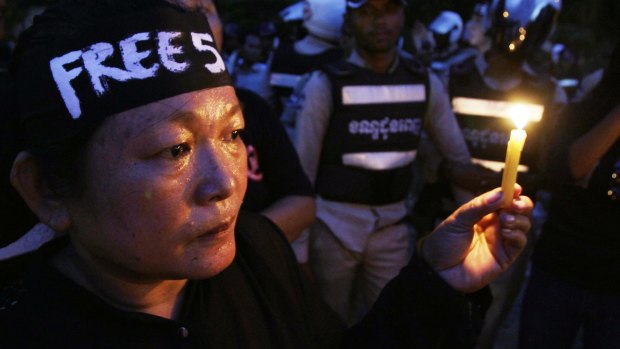 A demonstrator holds a candle in support of detained human rights activists in Phnom Penh on Monday.