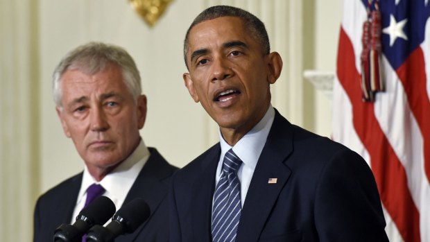 Warm words: Chuck Hagel listens as President Barack Obama talks about the Defence Secretary's resignation at the White House. 