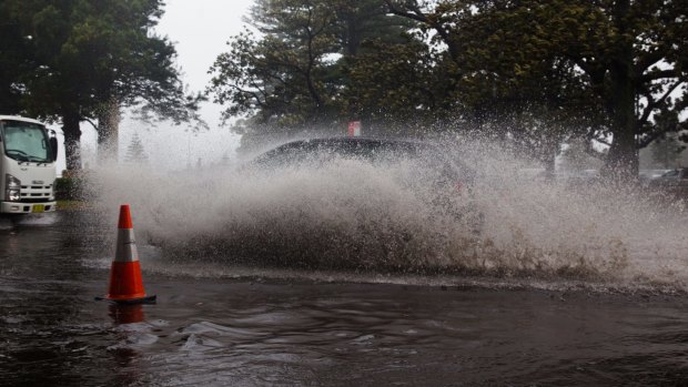 Motorists drive through the flood at New South Head Road in Rose Bay, Sydney, during the storm.