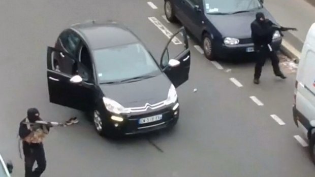 Gunmen flee the offices of French satirical newspaper Charlie Hebdo.