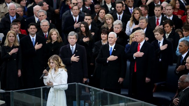 Jackie Evancho sings the US national anthem as Donald Trump looks on.