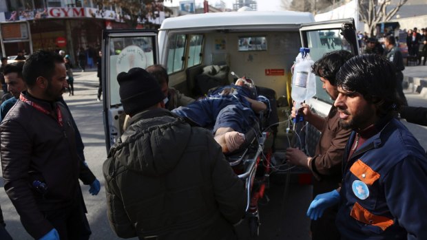 An injured man is moved by a stretcher outside a hospital following the suicide attack.